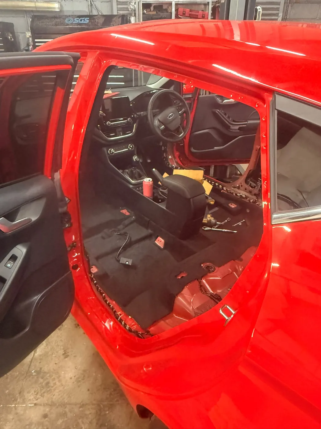 Car interior with seats and trim removed for repair work